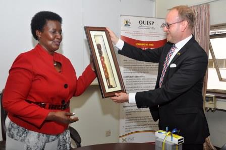 The outgoing ambassador of Sweden Urban Andersson receives a gift from the Minister of Trade Amelia Kyambadde during a farewell at the Ministry of Trade Headquarters in Kampala on August 9, 2016. Photo by Francis Emorut